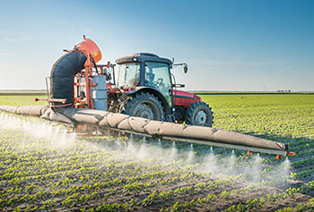 Photo d’un tracteur qui procède à l’application d’un pesticide dans un champ