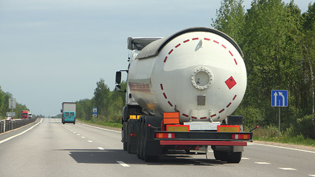 Photograph of a tanker truck being driven down a triple-lane highway